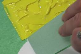 While the paint layer is still wet, the tape is pulled straight up from the surface.